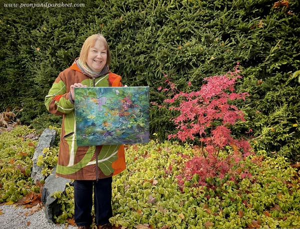 Paivi Eerola and her painting in the fall garden.