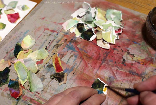 Painting the white edges of the torn paper collage.